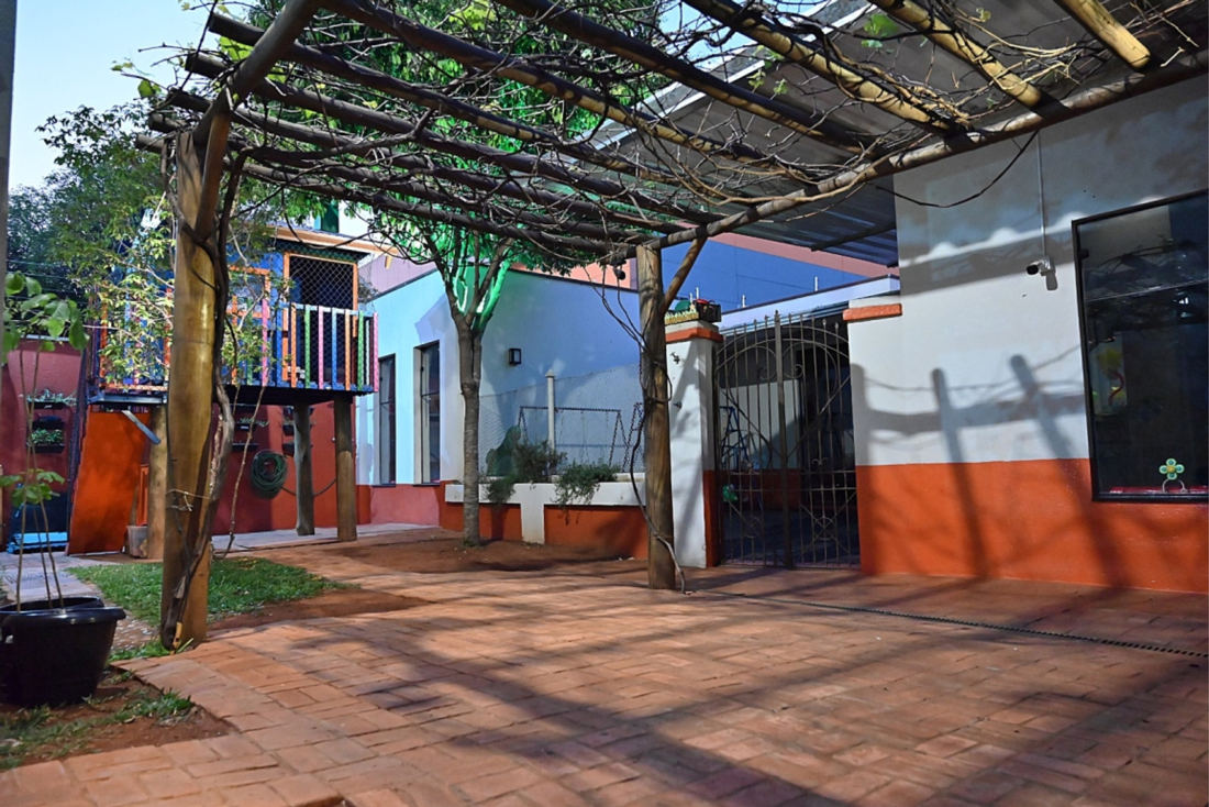 Área externa do buffet com pergolado de madeira e jardim