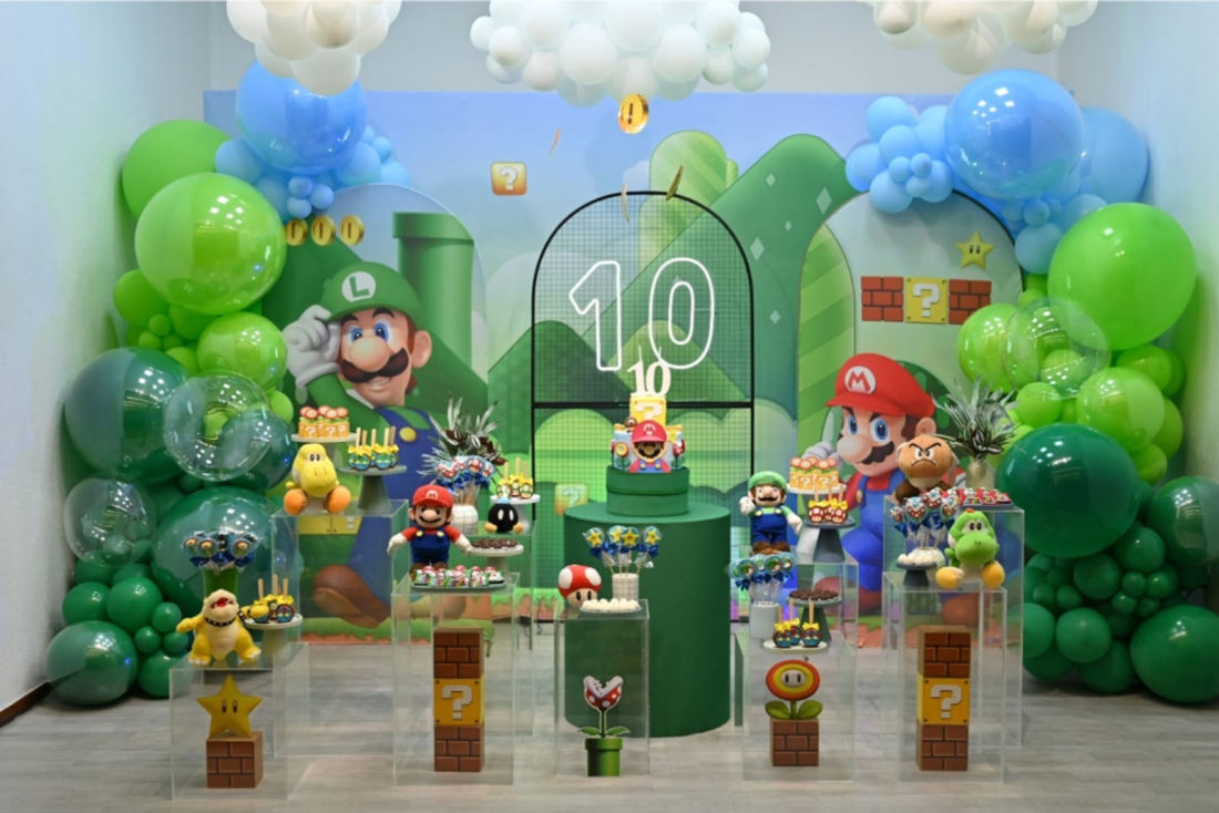 Decoração de festa com tema de videogame, painel verde e arco de balões
