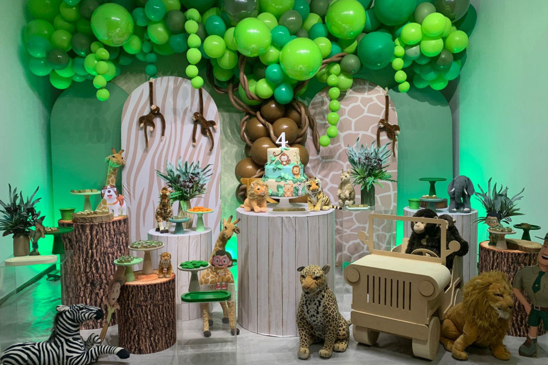 Decoração de festa com tema safari e arco de balões verdes